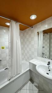 a bathroom with a sink and a tub and a shower at Britannia Hotel Bolton in Bolton