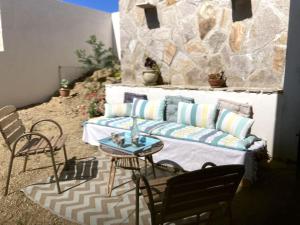 a patio with a couch and a table and chairs at Cavalière - RdJ villa 600m plage, 2 ch 6 pers, 3 étoiles grand confort in Le Lavandou
