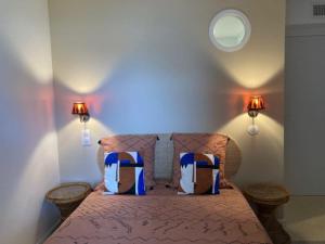 a bedroom with a bed with two pillows on it at Cavalière - RdJ villa 600m plage, 2 ch 6 pers, 3 étoiles grand confort in Le Lavandou