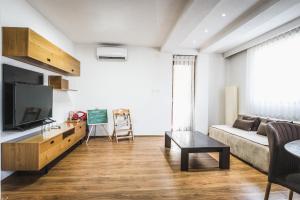 a living room with a couch and a tv at Nice Apartment in Gevgelija