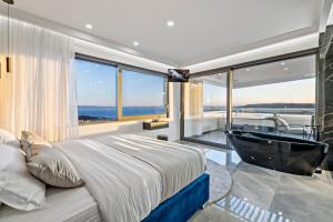 a bedroom with a tub and a bed with a large window at Villa Magnus in Makarska +45 photos