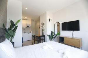 a bedroom with a bed and a living room at Stylish Modern Studios - Port & Beach Apartments, Haifa in Haifa