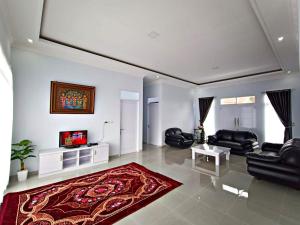 a living room with black furniture and a red rug at Villa Tiara 2 in Cikundul
