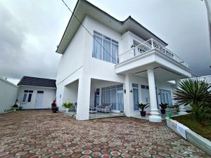 a white house with a balcony and a patio at Villa Tiara 2 in Cikundul