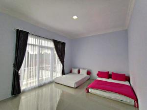 a bedroom with two beds and a large window at Villa Tiara 2 in Cikundul +19 photos