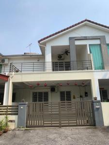 a large white house with a wooden fence in front of it at Happy inn home in Ipoh