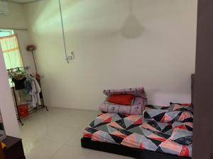 a bedroom with a bed with a colorful comforter at Happy inn home in Ipoh