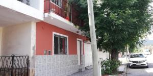 a red and white building with a car parked next to it at Casa particular Flavio in Salta