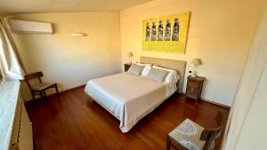 une chambre avec un lit blanc dans une pièce dans l'établissement La Mansarda, à Assise