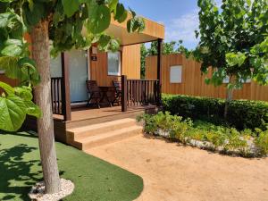 a home with a wooden porch with a tree at Camping Villasol in Benidorm