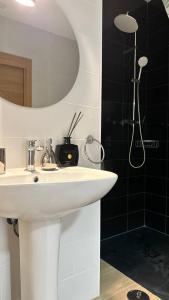 une salle de bain avec un lavabo blanc et une douche dans l'établissement Pensión Alicante Bergez, à Alicante