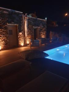 a swimming pool in front of a building at night at Agiannirema Ios Stone Houses with private pool in Psathi