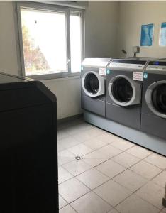 a laundry room with two washing machines and a window at Studio à 10 mins de Paris in Rosny-sous-Bois +5 photos