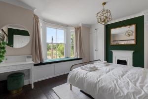 a green and white bedroom with a bed and a mirror at Quayside Haven in Exeter
