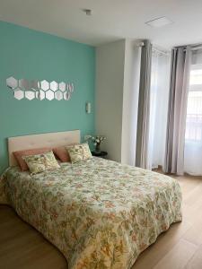 une chambre avec un grand lit et un mur bleu dans l'établissement Pensión Alicante Bergez, à Alicante 46 autres photos