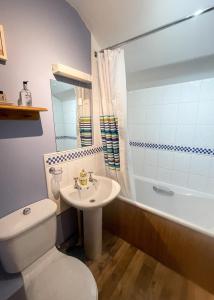 a bathroom with a toilet and a sink and a tub at Pretty Cottage In Charming Peaceful Village - Easy Commute to Cambridge - Cambridge Homehost in Cambridge +58 photos