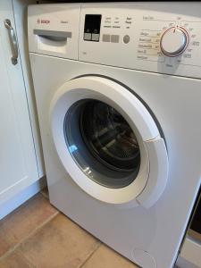 a white washing machine sitting in a kitchen at Pretty Cottage in peaceful village location - Easy Commute To Cambridge in Cambridge