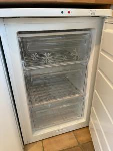an empty refrigerator door is open in a kitchen at Pretty Cottage in peaceful village location - Easy Commute To Cambridge in Cambridge