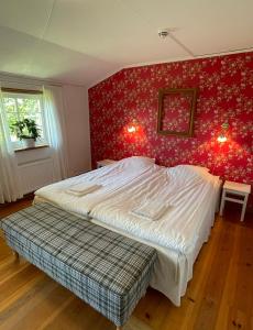 a bedroom with a bed and a red wall at Adagio på Österlen in Kivik