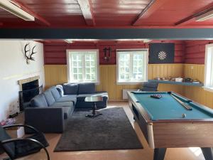 a living room with a couch and a pool table at Velferden Mågerø in Nord Måkerøy