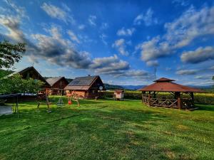 a yard with a playground and a gazebo at Domki nad Sanem in Lesko