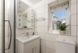 a white bathroom with a sink and a mirror at Oriel Cottage in St. Agnes +19 photos