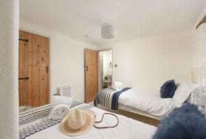 a bedroom with two beds with hats on top of them at Oriel Cottage in St. Agnes