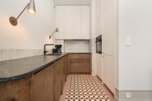 une cuisine avec des armoires blanches et un comptoir noir dans l'établissement Stylowy Apartament przy Rynku Głównym we Wrocławiu by Rent like home, à Wrocław