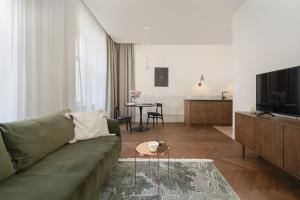 - un salon avec un canapé vert et une télévision dans l'établissement Stylowy Apartament przy Rynku Głównym we Wrocławiu by Rent like home, à Wrocław