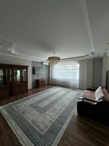 a large living room with a couch and a rug at Трехкомнатная просторная квартира 137 кв центре возле ТЦ Infinity Mall in Atyraū