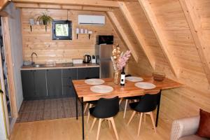a kitchen and dining table in a tiny house at Woodland Paradise Two charming wooden houses in the stone in Ljubuški