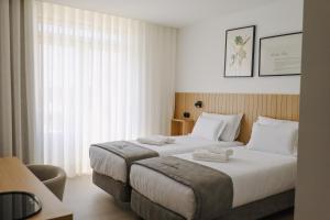 a hotel room with two beds and a window at Casa d'Albarróis in Alenquer