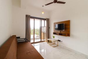 a living room with a couch and a flat screen tv at Casa Quina Heritage#5 in Taleigao