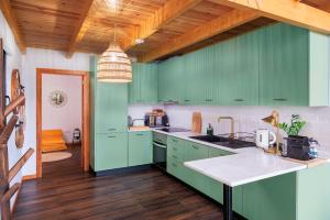 a kitchen with green cabinets and a wooden ceiling at Mountain Chalet by Lavibes in São Vicente