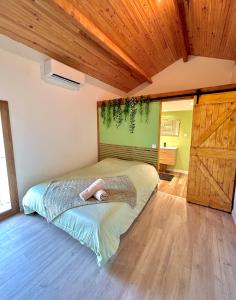 ein Schlafzimmer mit einem Bett und einer Holzdecke in der Unterkunft Gîte du mas Jubilé in Mons