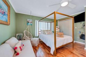 a bedroom with a canopy bed and a couch at Walk to North Beach in Clearwater Beach
