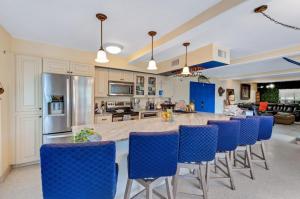 a large kitchen with blue chairs and a kitchen island at Walk to North Beach in Clearwater Beach