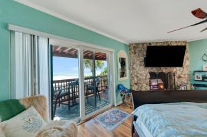 a bedroom with a bed and a balcony with a television at Walk to North Beach in Clearwater Beach