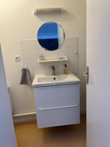a bathroom with a white sink and a mirror at Le Prieure Valette in Hérouville-Saint-Clair