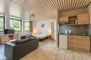 a living room with a couch and a bed and a kitchen at Condo Gardens Brussels in Brussels
