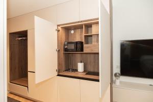 Una pequeña cocina con microondas y televisión. en Uus Volta, en Tallin