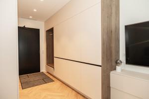 a hallway with white cabinets and a television at Uus Volta in Tallinn