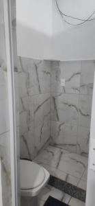 a bathroom with a toilet and a marble wall at Hospedagem Rio Lapa in Rio de Janeiro