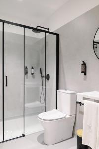 a white bathroom with a shower and a toilet at Casa d'Albarróis in Alenquer