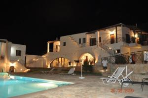 une grande maison blanche avec une piscine la nuit dans l'établissement Ferienhaus mit Privatpool für 12 Personen in Agia Galini, Kreta, à Agia Galini