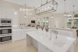 a kitchen with white cabinets and a large white island at 298 5 Bedrooms Fenced yard New Construction in Robstown