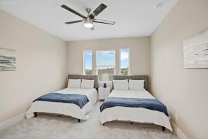 two beds in a room with a ceiling fan at 298 5 Bedrooms Fenced yard New Construction in Robstown