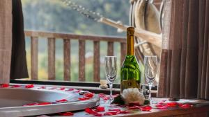 a table with a bottle of champagne and two glasses at Estalagem Mandeville in Monte Verde