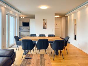 a conference room with a wooden table and chairs at T&K Apartments - Mettmann - Schöne 5 Zimmer Maisonette - 20min Messe Fair DUS in Mettmann