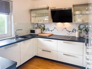 a kitchen with white cabinets and a sink at T&K Apartments - Mettmann - Schöne 5 Zimmer Maisonette - 20min Messe Fair DUS in Mettmann